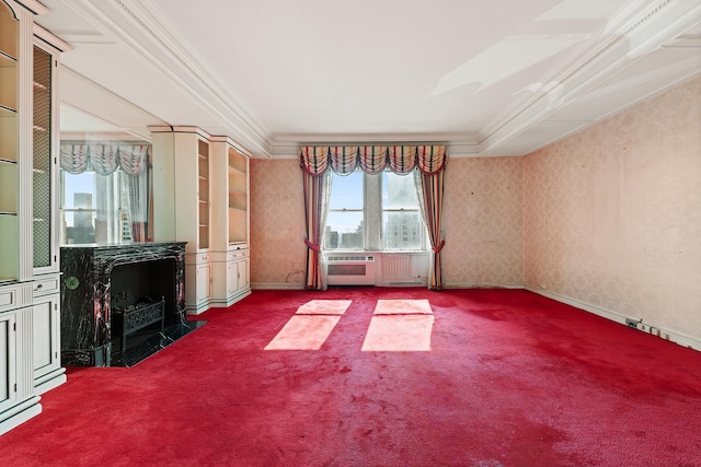 unfurnished living room with ornamental molding, a wood stove, carpet flooring, baseboards, and wallpapered walls