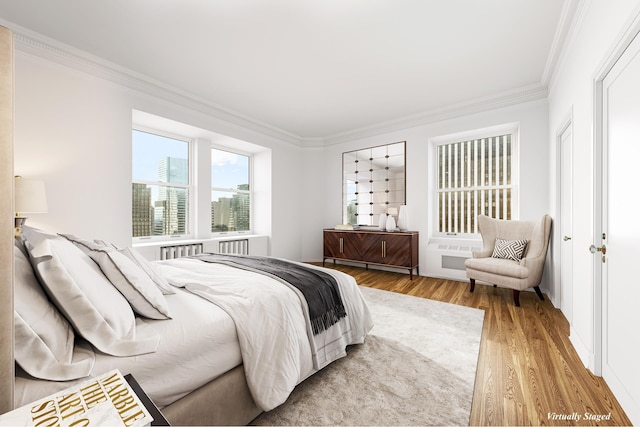 bedroom with radiator heating unit, wood finished floors, and crown molding