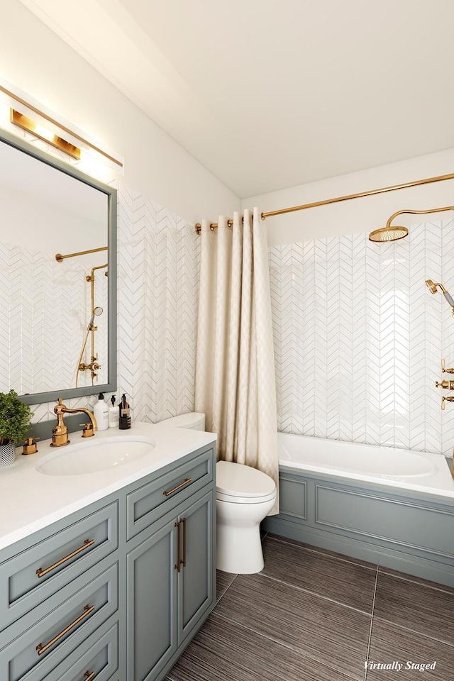 full bathroom featuring washtub / shower combination, vanity, and toilet