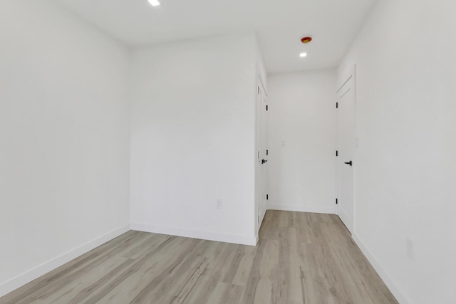 spare room featuring recessed lighting, baseboards, and light wood-style floors