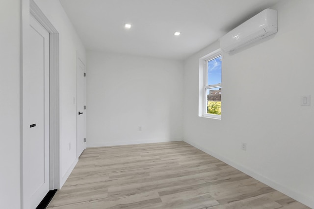 unfurnished bedroom with light wood-style flooring, recessed lighting, and a wall mounted AC