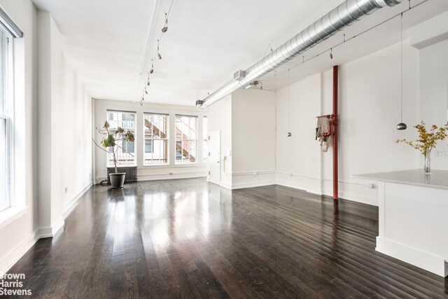 bedroom with dark hardwood / wood-style floors and radiator