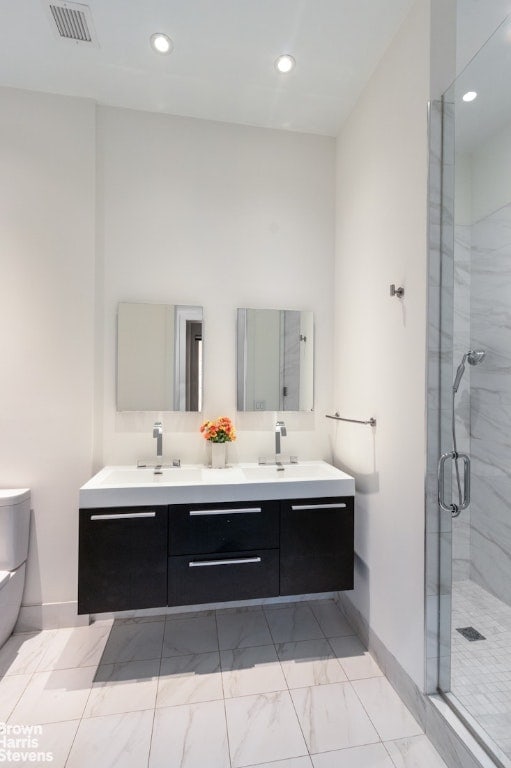 bathroom with vanity, a shower with shower door, and toilet