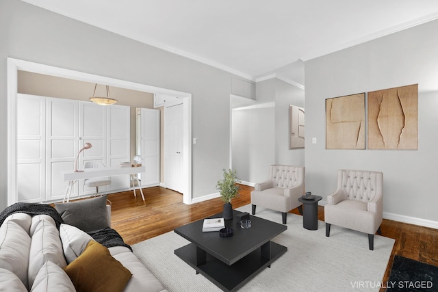 living area featuring crown molding, baseboards, and wood finished floors