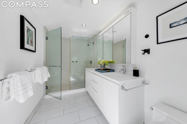 bathroom with tile patterned floors, toilet, an enclosed shower, and vanity