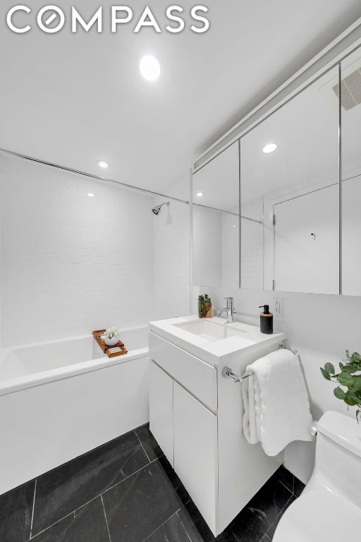 full bathroom featuring vanity, shower / washtub combination, tile patterned floors, and toilet