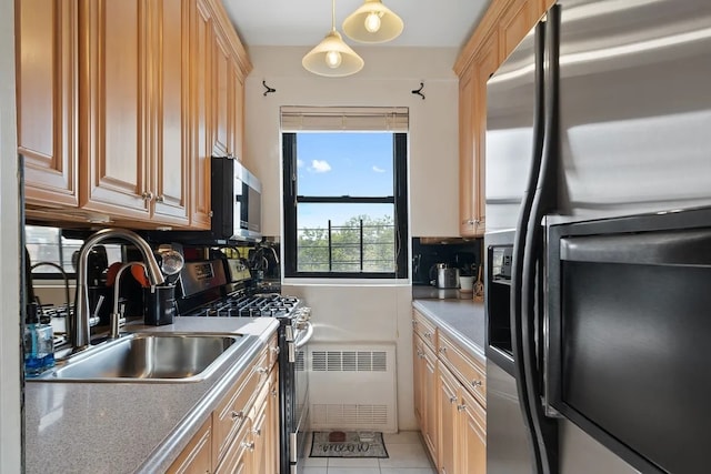 kitchen with appliances with stainless steel finishes, light brown cabinetry, sink, hanging light fixtures, and light tile patterned flooring