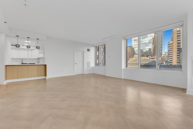 15 W 63rd St Unit 17-A, New York City, NY 10023 - unfurnished living room featuring baseboards