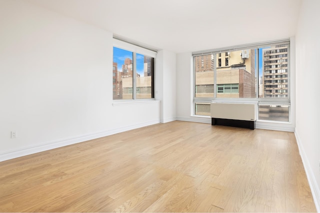 empty room with baseboards and wood finished floors