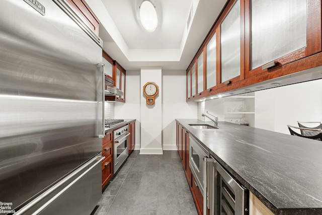 kitchen with beverage cooler, stainless steel appliances, a sink, baseboards, and glass insert cabinets