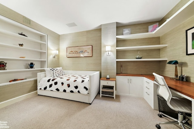 bedroom featuring built in desk and light colored carpet