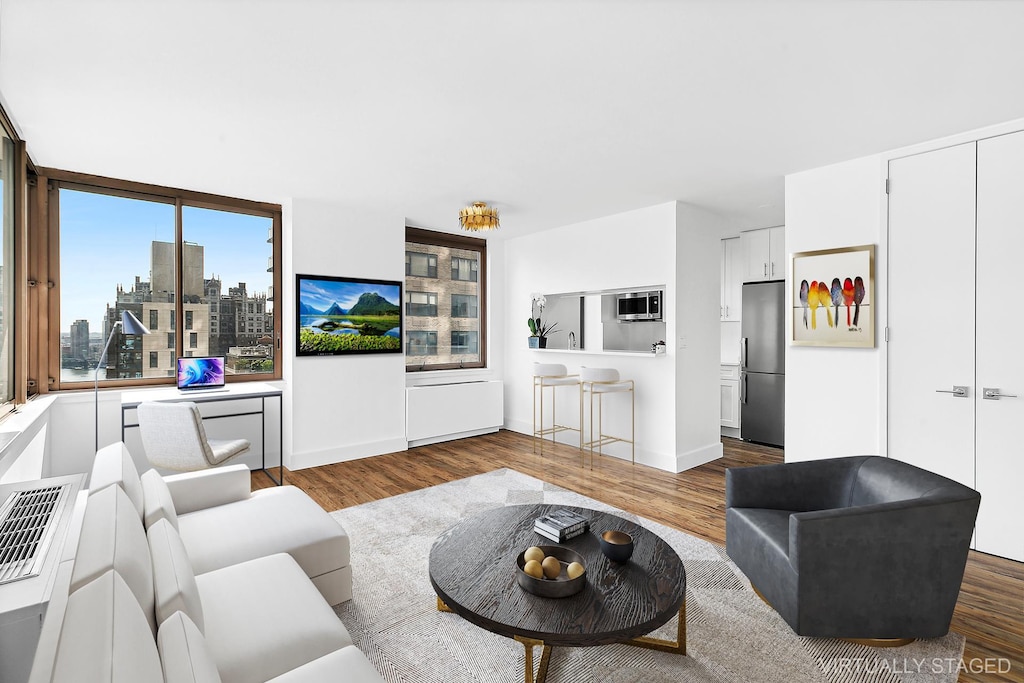 living area with baseboards and dark wood-style floors