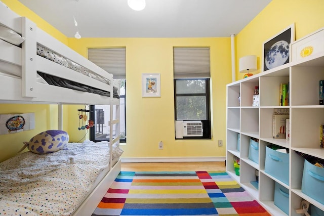 bedroom with cooling unit and light hardwood / wood-style floors