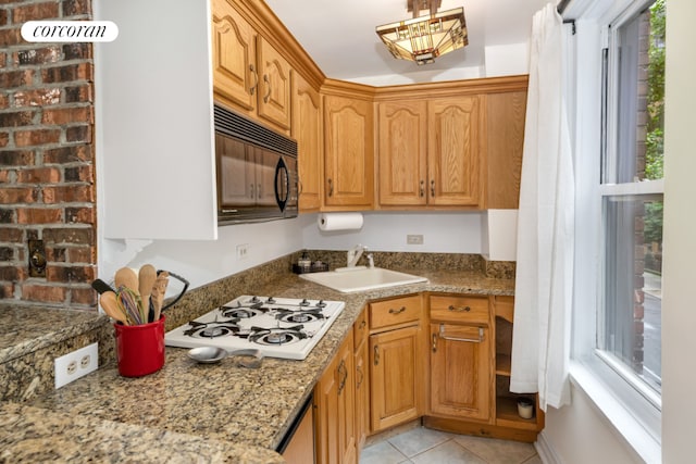 kitchen with light tile patterned floors, white gas cooktop, sink, and a wealth of natural light