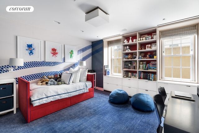 bedroom featuring dark carpet and multiple windows