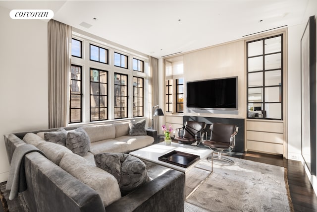 living area featuring visible vents, plenty of natural light, and wood finished floors