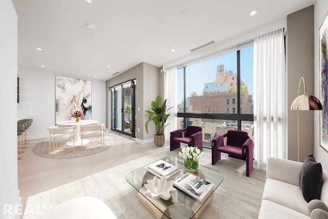 living area featuring baseboards, visible vents, a city view, and recessed lighting