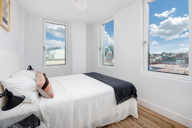 bedroom with hardwood / wood-style flooring and multiple windows