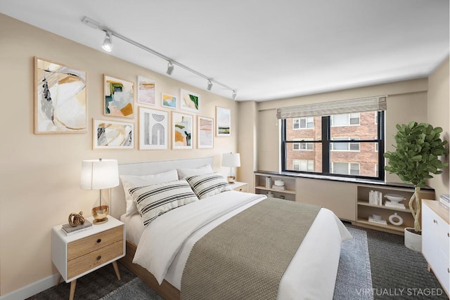 carpeted bedroom with rail lighting