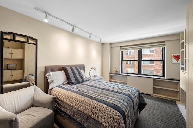 carpeted bedroom featuring rail lighting