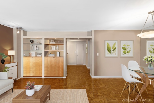 living room with built in features and baseboards