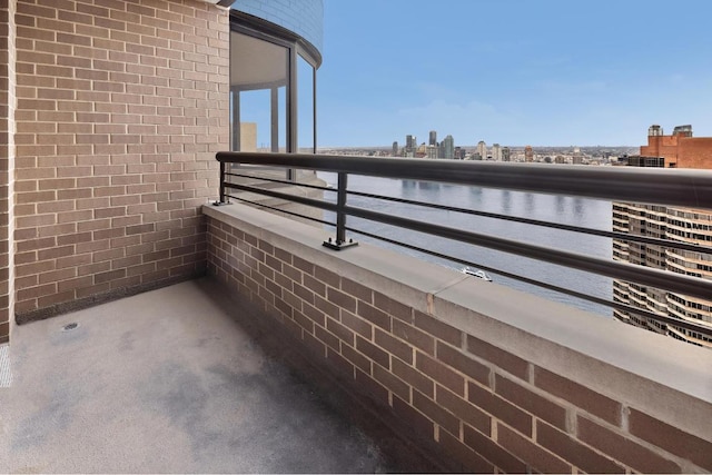 balcony with a water view and a view of city