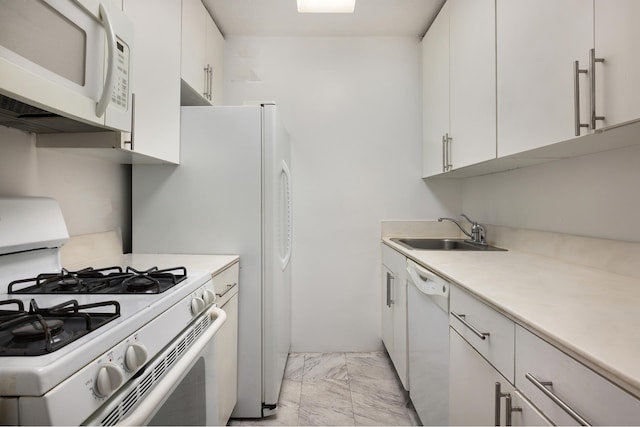 kitchen with white appliances, a sink, light countertops, white cabinets, and marble finish floor