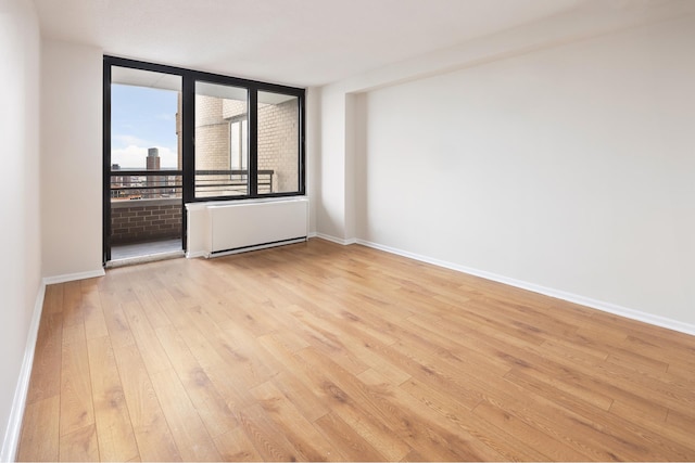 empty room with light wood finished floors and baseboards