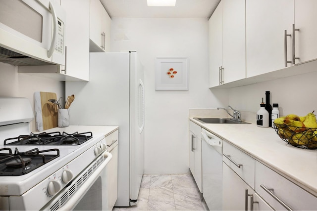 kitchen with white appliances, a sink, light countertops, white cabinets, and marble finish floor