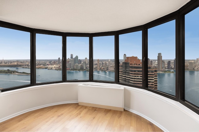 unfurnished sunroom with a city view and a water view