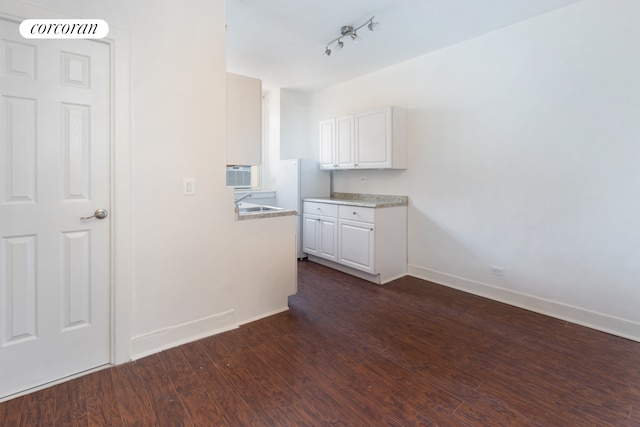 kitchen with baseboards, dark wood-style flooring, freestanding refrigerator, light countertops, and white cabinetry