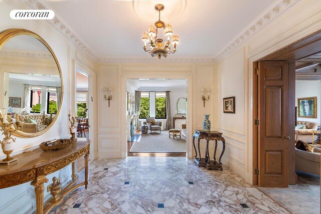 entrance foyer with crown molding and a notable chandelier