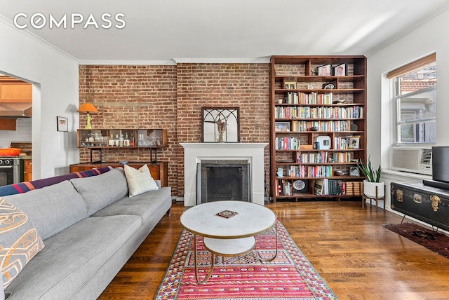 living area with crown molding, cooling unit, a fireplace, and wood finished floors