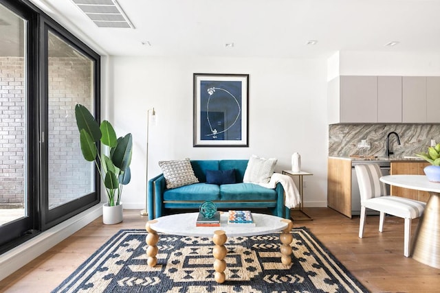 living room featuring light wood-type flooring and sink