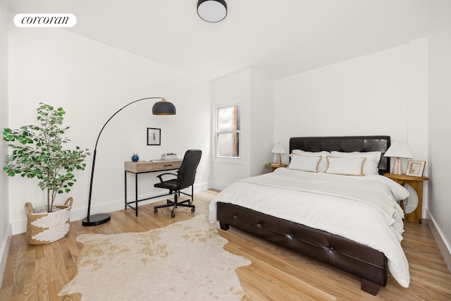 bedroom featuring visible vents, baseboards, and wood finished floors