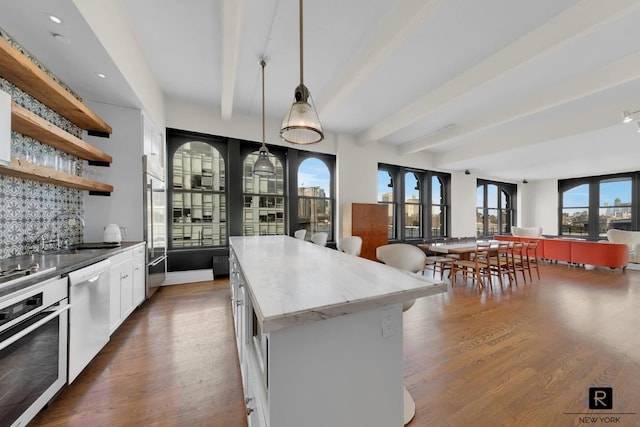 kitchen featuring appliances with stainless steel finishes, pendant lighting, white cabinetry, open shelves, and a sink