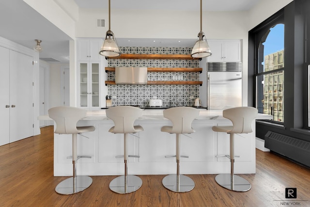 30 Main St Unit 11-G, New York City, NY 11201 - kitchen with built in refrigerator, open shelves, wood finished floors, and backsplash