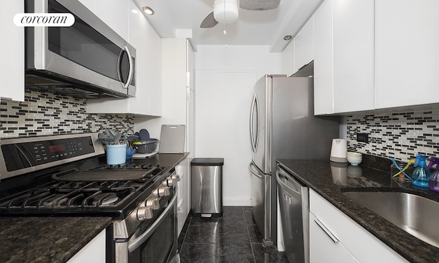 kitchen featuring white cabinetry, appliances with stainless steel finishes, and dark stone counters