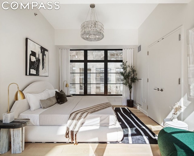 bedroom featuring light hardwood / wood-style flooring and an inviting chandelier