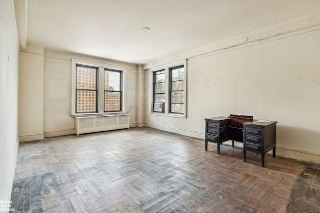 unfurnished room featuring radiator, a wood stove, and baseboards