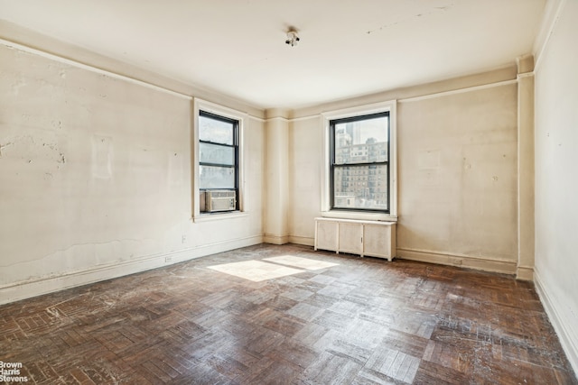 empty room featuring cooling unit, baseboards, and radiator heating unit