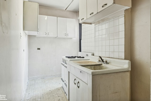 kitchen featuring light countertops, white cabinetry, and white gas range