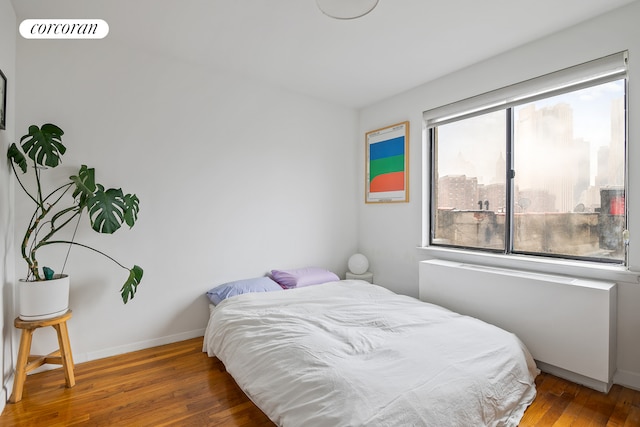 bedroom with visible vents, baseboards, and wood finished floors