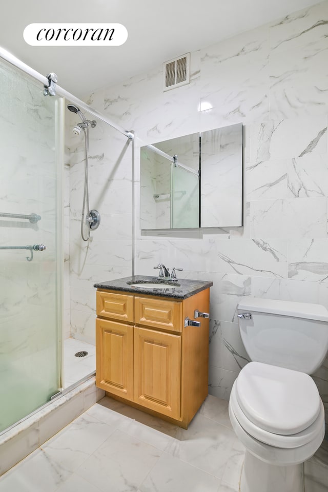 bathroom featuring toilet, vanity, visible vents, marble finish floor, and a marble finish shower