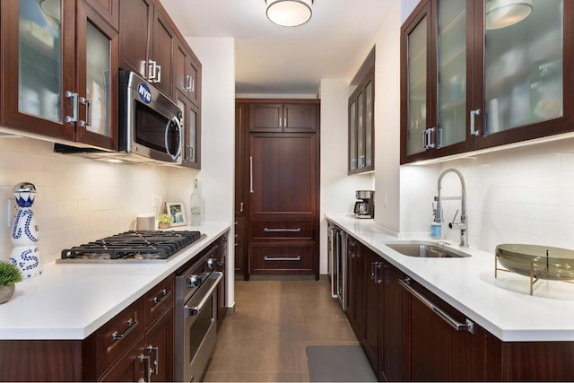 kitchen featuring decorative backsplash, sink, dark brown cabinetry, and appliances with stainless steel finishes