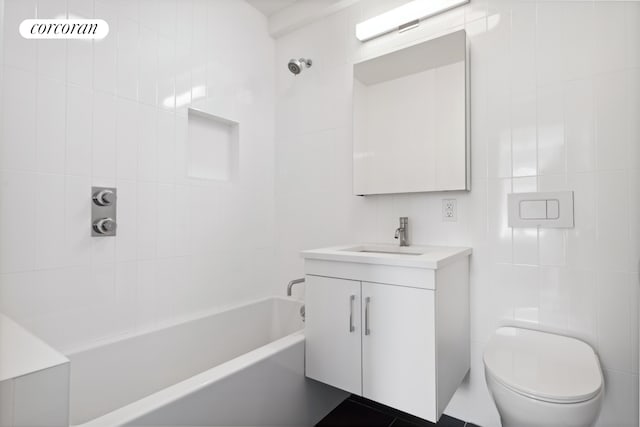 bathroom with toilet, tile walls, vanity, and  shower combination