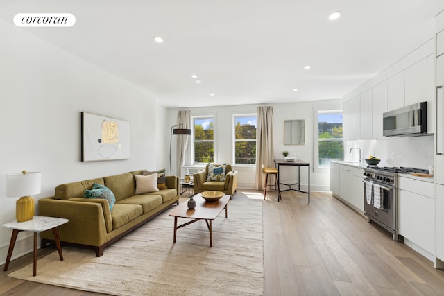 living room featuring recessed lighting, visible vents, and light wood finished floors