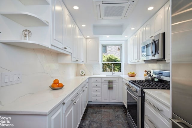 kitchen featuring light stone counters, white cabinets, and stainless steel appliances