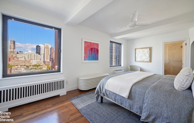 bedroom with ceiling fan, radiator, and dark wood-type flooring