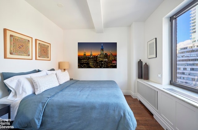 bedroom featuring dark wood-type flooring and beam ceiling